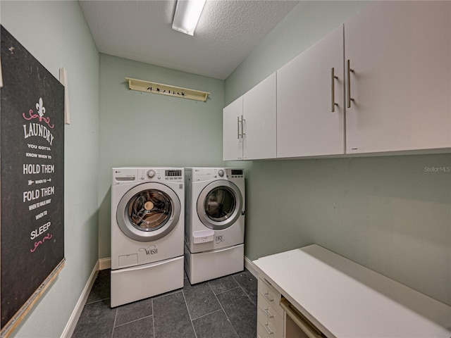 laundry room with baseboards, cabinet space, a textured ceiling, and washing machine and clothes dryer