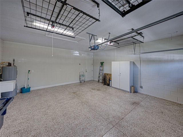 garage with concrete block wall, a garage door opener, and water heater