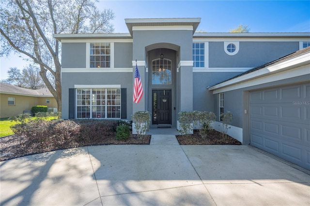 view of front of property with a garage, concrete driveway, and stucco siding