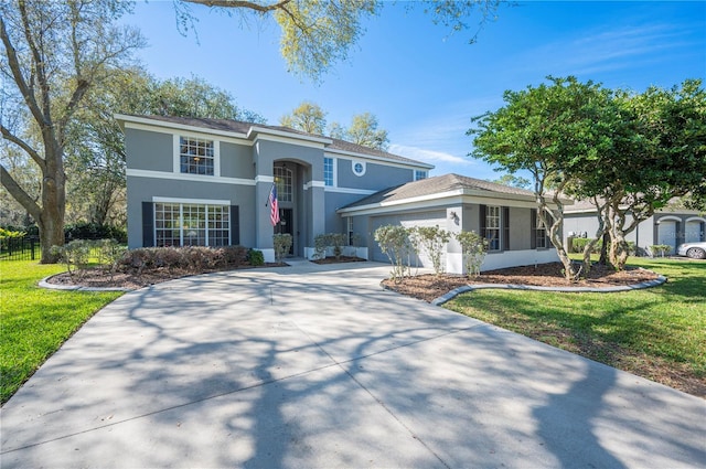 view of front of house featuring concrete driveway, a front yard, an attached garage, and stucco siding