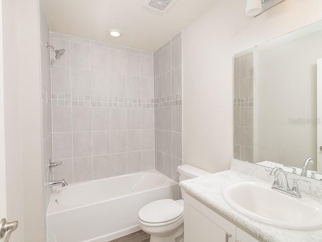 bathroom with bathtub / shower combination, visible vents, vanity, and toilet