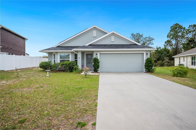 view of front of house featuring a garage, fence, driveway, stucco siding, and a front yard