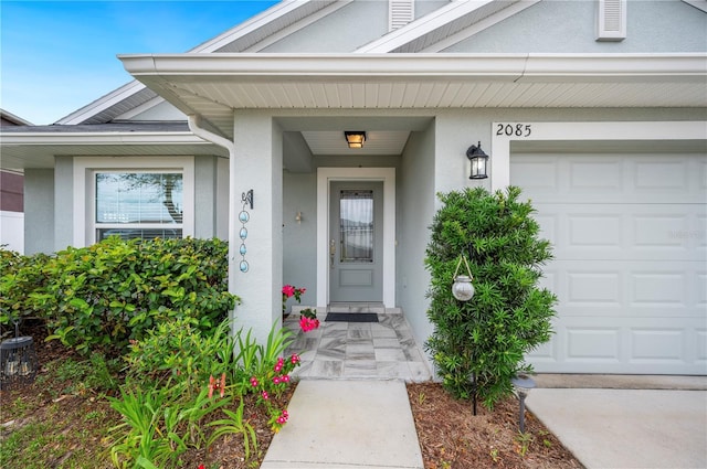 property entrance with an attached garage and stucco siding