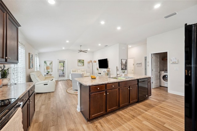 kitchen featuring visible vents, washer / clothes dryer, open floor plan, black appliances, and a sink