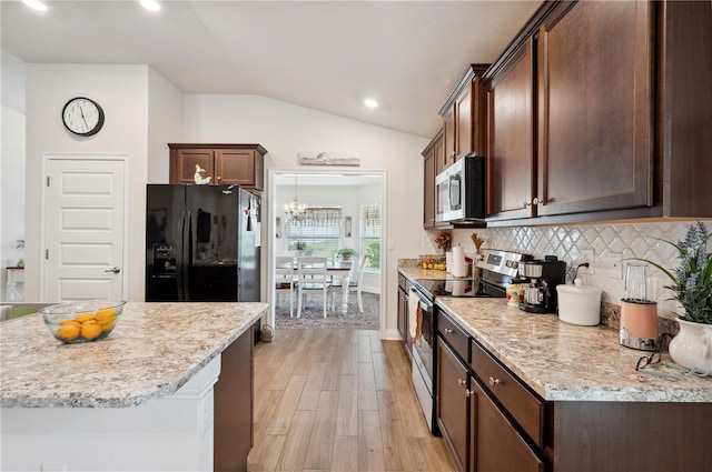 kitchen with lofted ceiling, stainless steel appliances, dark brown cabinets, and tasteful backsplash