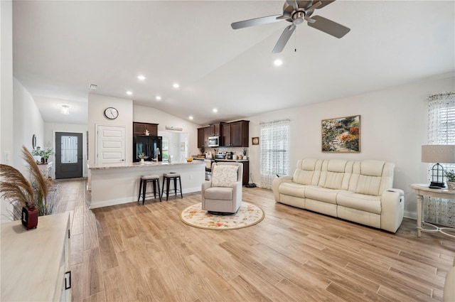 living room with light wood-style floors, lofted ceiling, baseboards, and recessed lighting