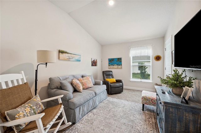 carpeted living area featuring lofted ceiling and baseboards