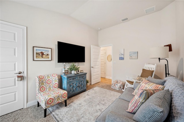 carpeted living room featuring vaulted ceiling, visible vents, and baseboards