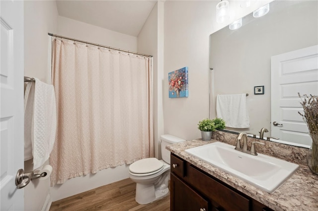 full bath featuring toilet, shower / bath combo, wood finished floors, and vanity