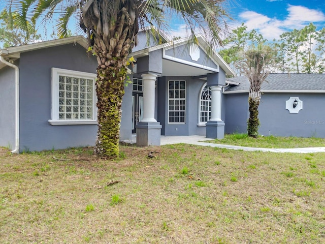 view of front of property featuring a front yard and stucco siding