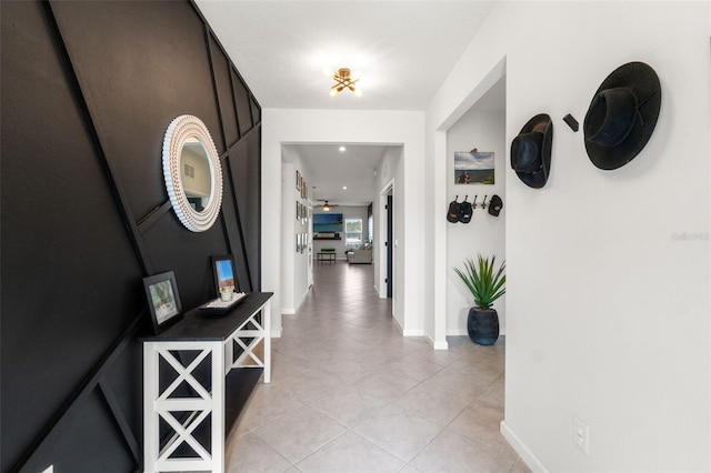 hallway featuring light tile patterned floors and baseboards