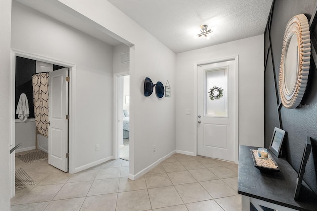 entryway with light tile patterned flooring, visible vents, and baseboards