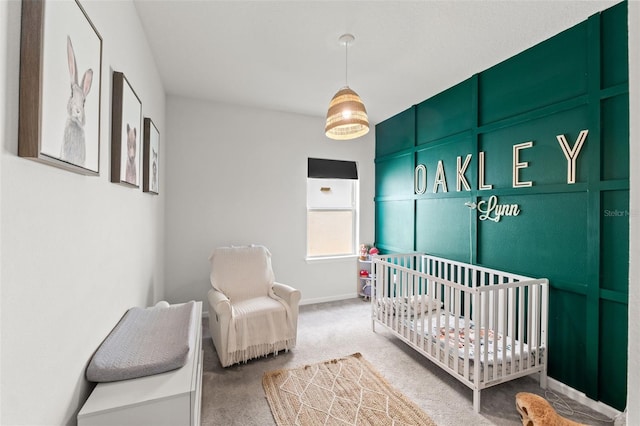 bedroom featuring a crib, baseboards, and carpet floors