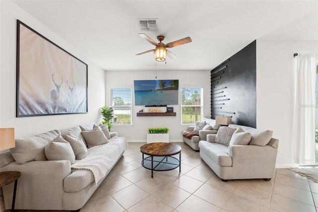 living area with baseboards, light tile patterned flooring, visible vents, and a ceiling fan