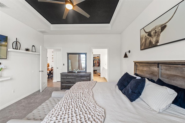 carpeted bedroom with a raised ceiling, visible vents, ceiling fan, and baseboards