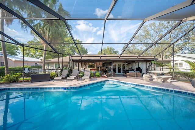 pool featuring glass enclosure, a patio area, french doors, and an outdoor hangout area