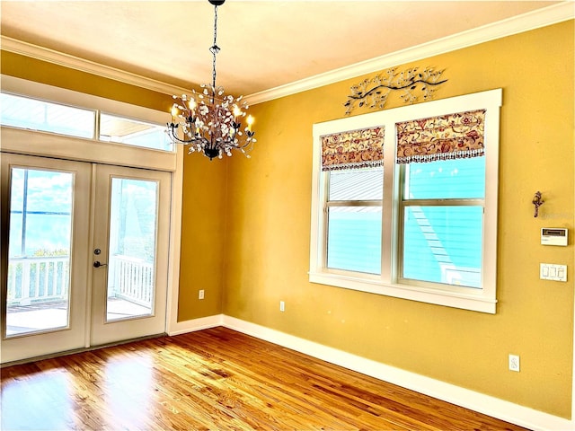 interior space featuring french doors, crown molding, an inviting chandelier, wood finished floors, and baseboards