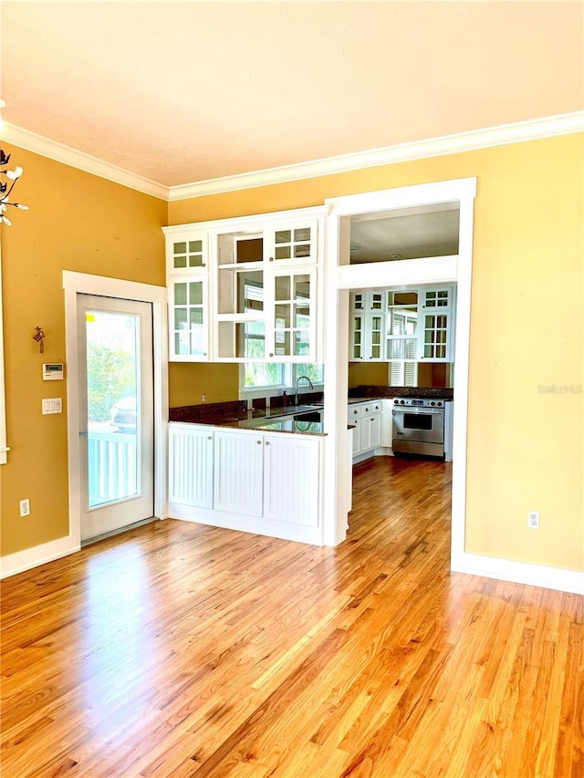 kitchen featuring crown molding, dark countertops, high end range, and white cabinets