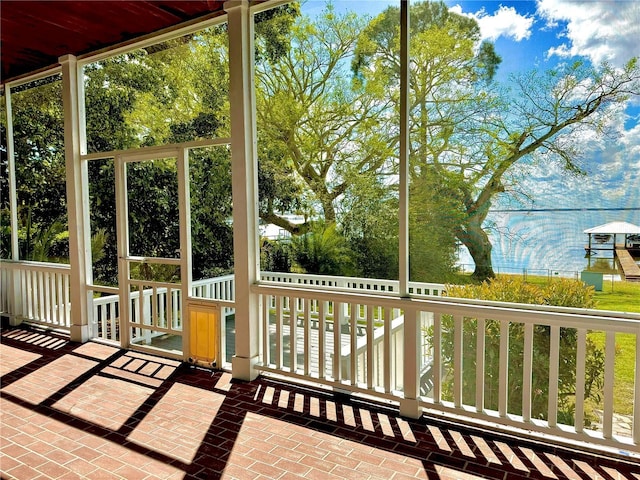 unfurnished sunroom featuring a water view