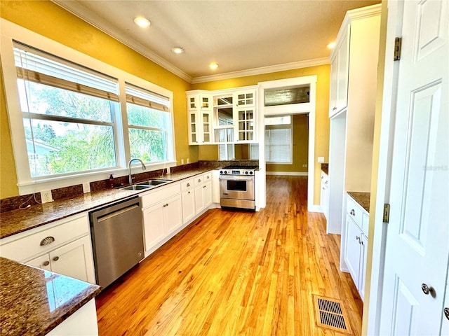 kitchen featuring visible vents, stainless steel appliances, a sink, and ornamental molding