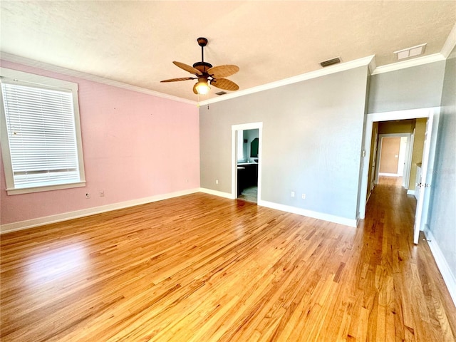 spare room featuring ornamental molding, baseboards, visible vents, and light wood finished floors