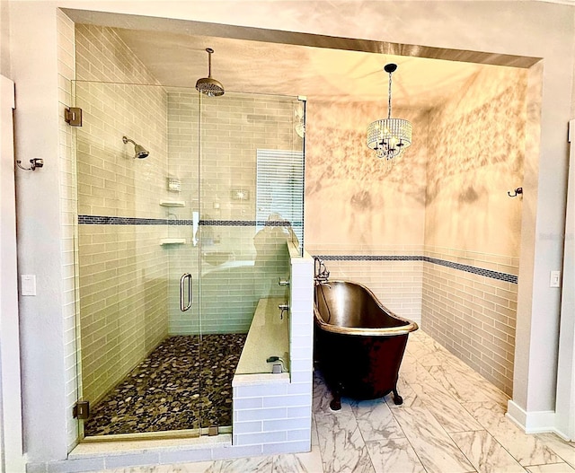 full bathroom with marble finish floor, a shower stall, and a soaking tub