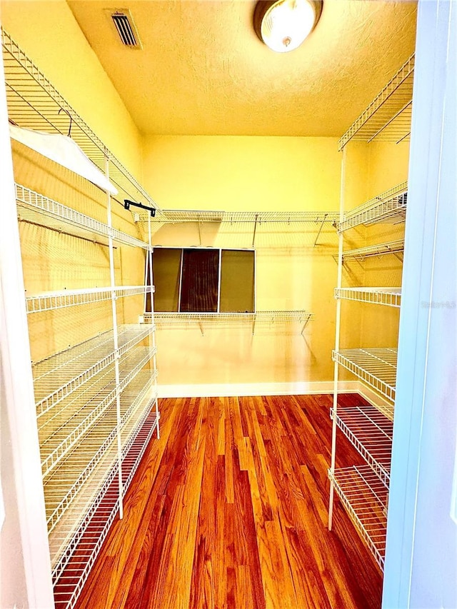 walk in closet with wood finished floors and visible vents