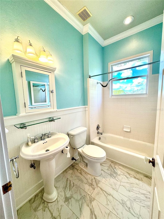 bathroom with marble finish floor, wainscoting, visible vents, and crown molding