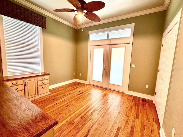 entrance foyer featuring french doors, light wood-style flooring, ornamental molding, a ceiling fan, and baseboards