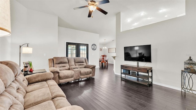 living room with baseboards, a towering ceiling, dark wood-type flooring, french doors, and ceiling fan with notable chandelier