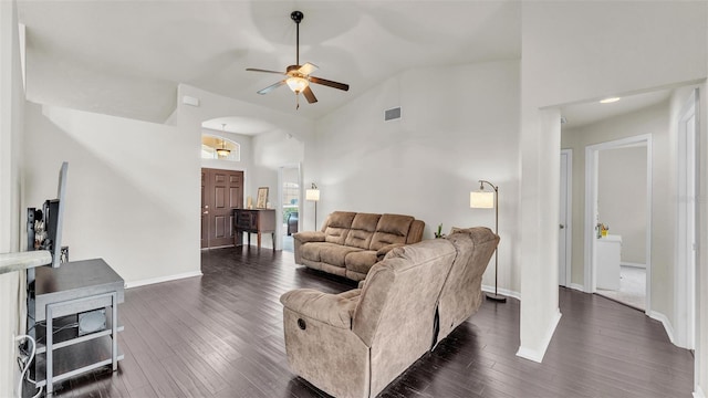 living area featuring arched walkways, high vaulted ceiling, dark wood-style flooring, visible vents, and baseboards