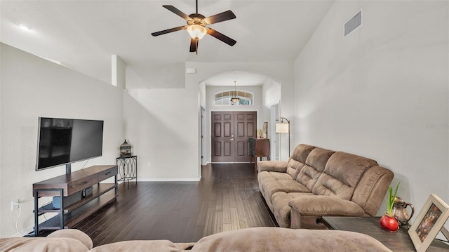 living room with dark wood-style floors, arched walkways, visible vents, ceiling fan, and baseboards