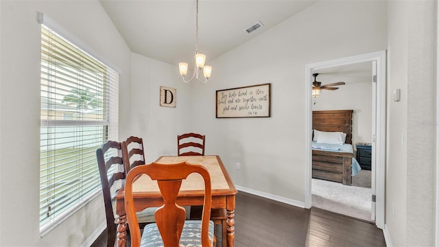 dining space featuring dark wood finished floors, lofted ceiling, visible vents, baseboards, and ceiling fan with notable chandelier