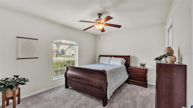 carpeted bedroom with ceiling fan and baseboards