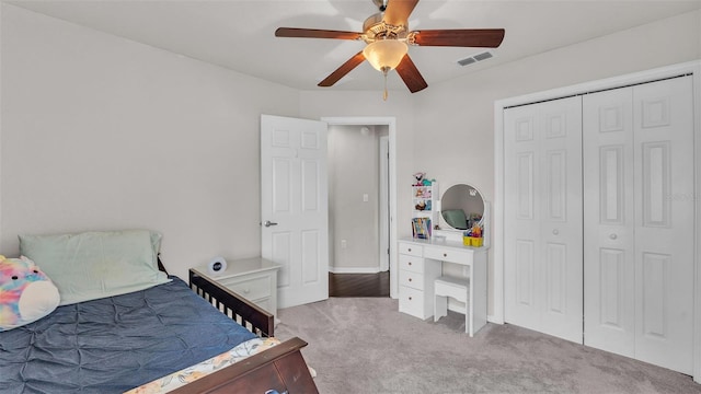 carpeted bedroom featuring a ceiling fan, a closet, and visible vents