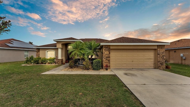 view of front of home with a garage, concrete driveway, stone siding, stucco siding, and a front yard