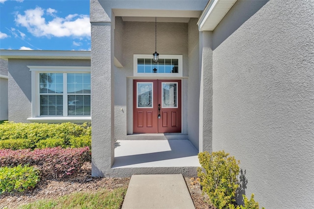 doorway to property featuring stucco siding