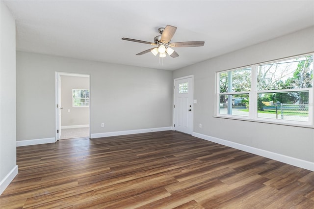 unfurnished room with baseboards and dark wood-style flooring