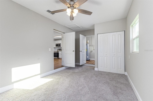 unfurnished bedroom with visible vents, a closet, carpet flooring, baseboards, and attic access