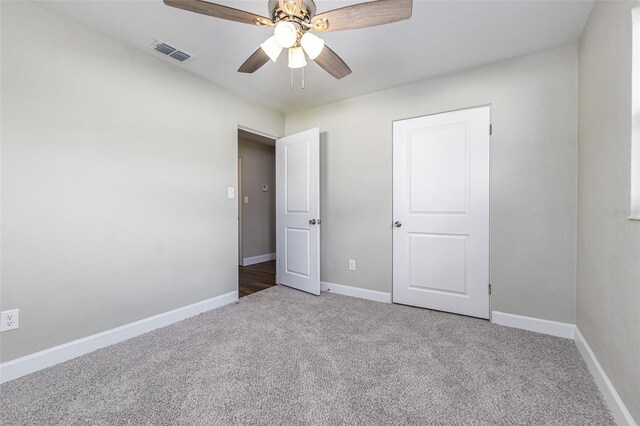 unfurnished bedroom with visible vents, baseboards, carpet, and a ceiling fan