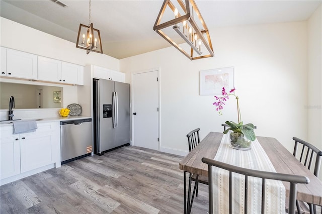 dining area featuring light wood finished floors and a chandelier