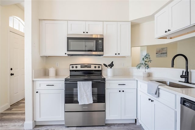 kitchen featuring a sink, light countertops, white cabinets, and stainless steel appliances