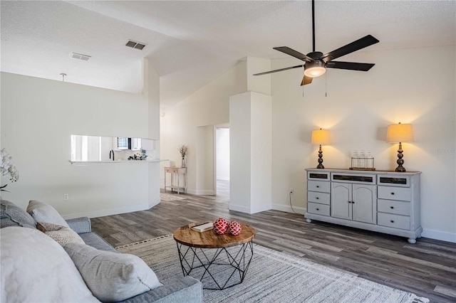 living area featuring a textured ceiling, wood finished floors, visible vents, and ceiling fan