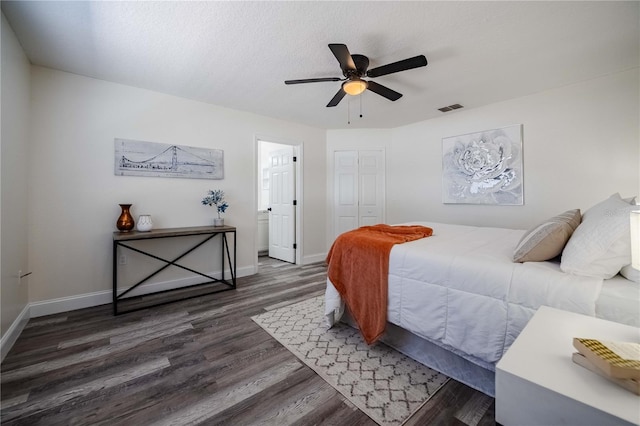 bedroom featuring wood finished floors, visible vents, baseboards, ceiling fan, and a textured ceiling