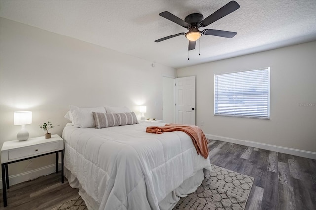 bedroom with ceiling fan, baseboards, a textured ceiling, and wood finished floors