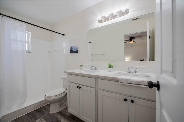 full bathroom featuring ceiling fan, double vanity, toilet, and a sink