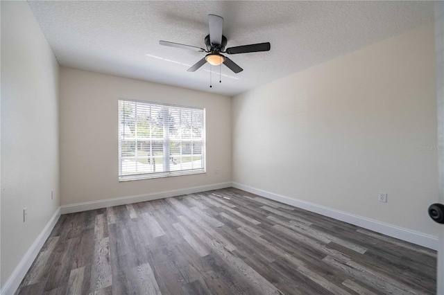 spare room featuring a textured ceiling, baseboards, and dark wood-style flooring