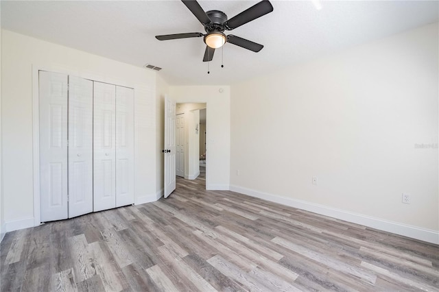 unfurnished bedroom with visible vents, a ceiling fan, a closet, light wood finished floors, and baseboards