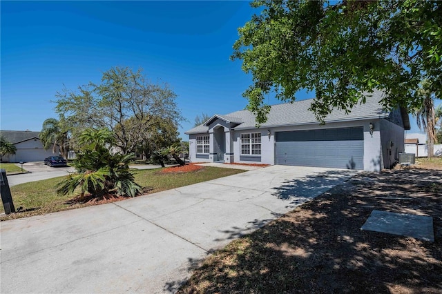 single story home featuring central AC, concrete driveway, a garage, and roof with shingles