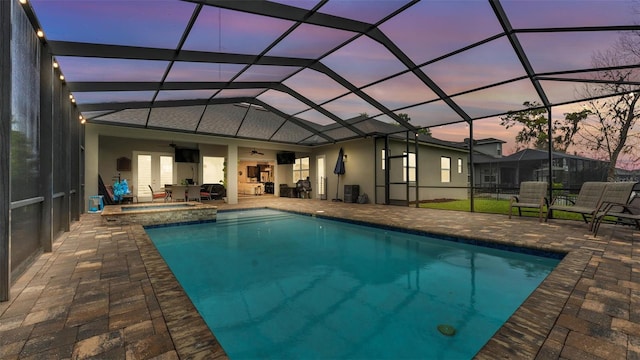 view of pool with glass enclosure, a patio, ceiling fan, and a pool with connected hot tub